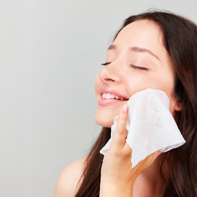 Woman gently using expanded towel on her face